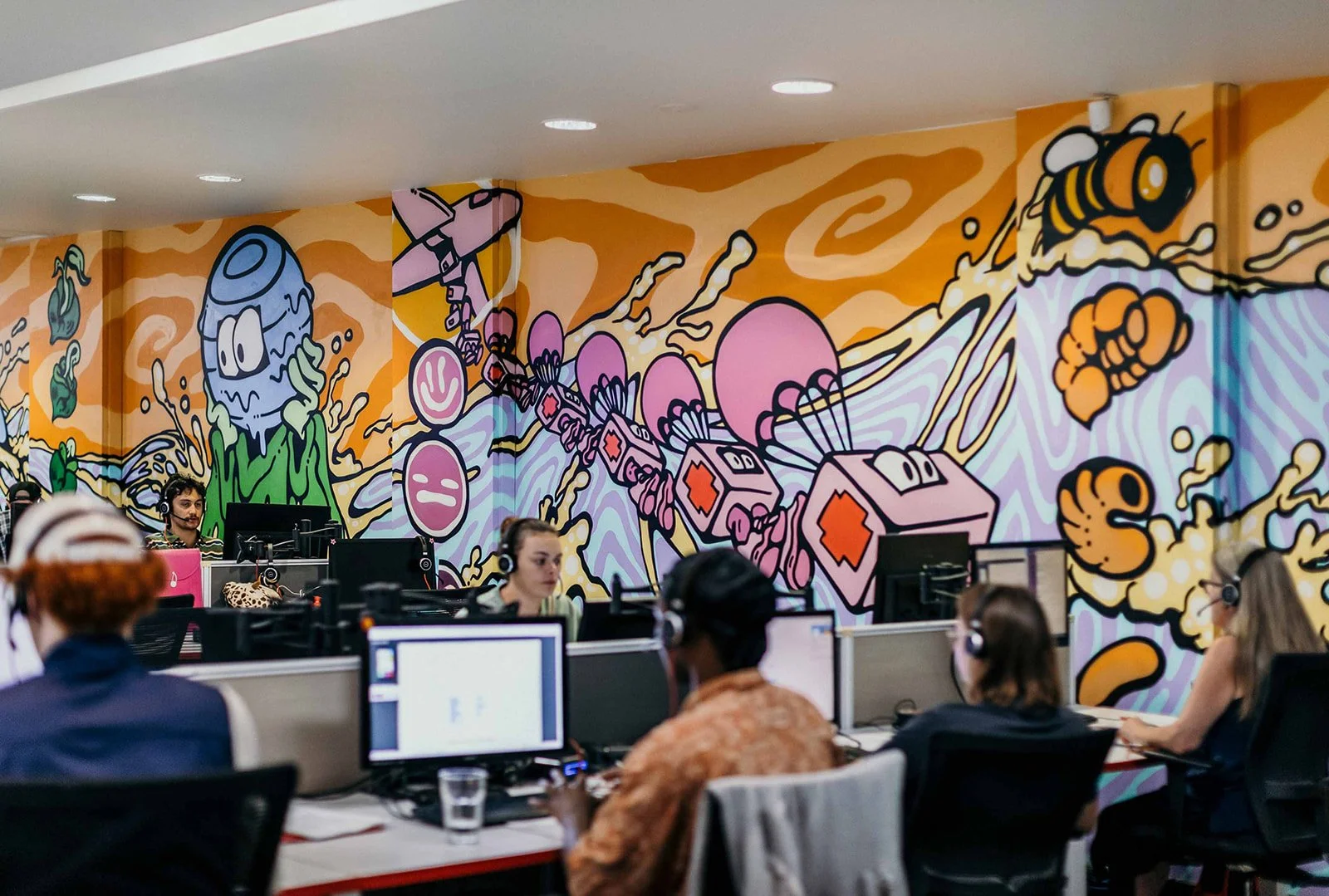 GiveTel callers at work in a colourful office