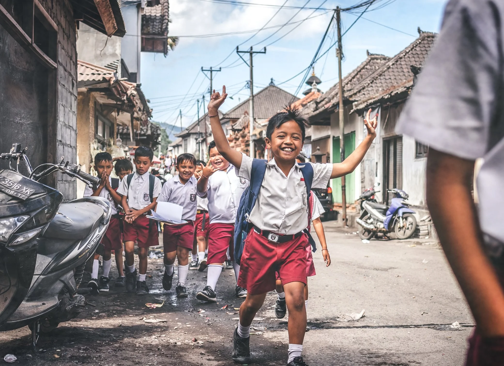 Children smiling and walking together on a street